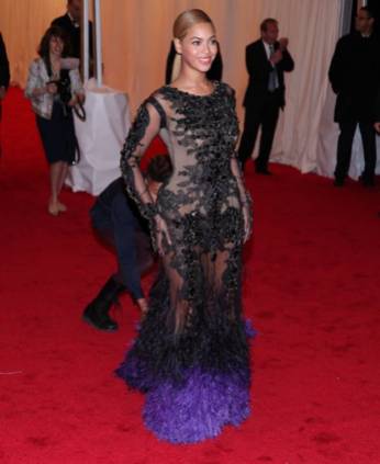 Queen B in black lace gown with purple ostrich feather trim